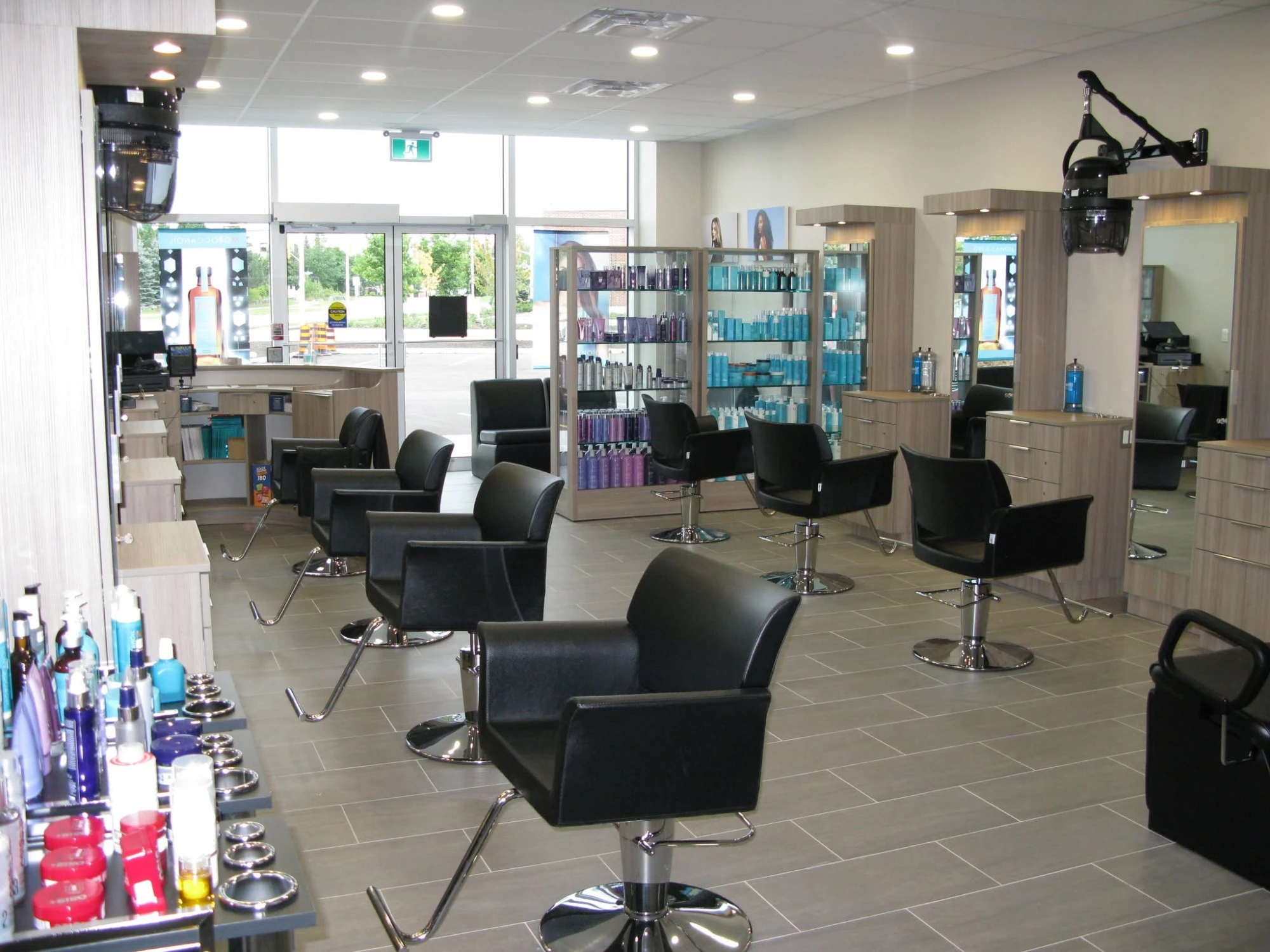 Rows of black styling chairs, mirrors and product shelves inside Friendly Cuts Kanata